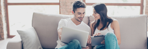 couple-looking-at-laptop-on-sofa_2.png