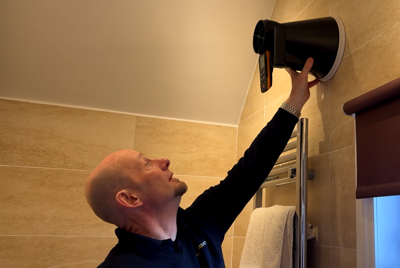 man-inspecting-bathroom-ventilation